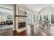 Open living area with a fireplace, views of the breakfast nook, and hardwood floors at 12370 Preserve Ln, Johns Creek, GA 30005