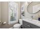 Stylish powder room with modern vanity, framed art, and a window providing natural light at 12370 Preserve Ln, Johns Creek, GA 30005