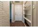 Hallway with storage shelving, a brick wall, and hardwood style flooring at 2345 Leith Ave, Atlanta, GA 30344