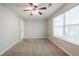 This bedroom features neutral paint, carpet, and a ceiling fan with a window for natural light at 3568 Oakshire Se Way, Atlanta, GA 30354