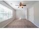 Bedroom featuring neutral paint, carpet, ceiling fan, and a large window at 3568 Oakshire Se Way, Atlanta, GA 30354