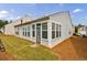 View of home exterior and backyard with attached sunroom addition and lawn at 4265 Prince Charles Dr, Duluth, GA 30097