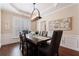 Stylish dining room with elegant lighting, hardwood floors, and a view of the manicured yard at 4265 Prince Charles Dr, Duluth, GA 30097