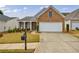 Charming brick home featuring a two-car garage, manicured lawn, and inviting front porch at 4265 Prince Charles Dr, Duluth, GA 30097