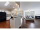 Open kitchen and living room with hardwood floors, white cabinetry, and stainless steel appliances at 4265 Prince Charles Dr, Duluth, GA 30097
