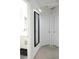 Bright hallway featuring neutral carpet, doors, and a framed mirror with modern lighting at 745 Abbotts Mill Ct, Johns Creek, GA 30097