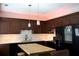 Stylish eat-in kitchen with dark wood cabinets, a center island, and granite countertops at 745 Abbotts Mill Ct, Johns Creek, GA 30097