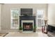 Cozy living room featuring a fireplace, large windows, and neutral decor at 745 Abbotts Mill Ct, Johns Creek, GA 30097