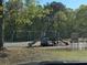 Community playground with swings and slides amidst mature trees and green space at 1235 Jasmine Green Ct, Dacula, GA 30019