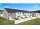 Backyard view of townhomes with gray and brick accents, green lawns, and privacy fences at 290 Silver Moon Drive # 111, Loganville, GA 30052