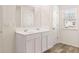 Bathroom featuring double sinks, vanity with white cabinets, tiled floors and natural light at 290 Silver Moon Drive # 111, Loganville, GA 30052