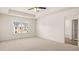 Primary bedroom featuring a tray ceiling, carpet, a window, and an attached bathroom with tile flooring at 290 Silver Moon Drive # 111, Loganville, GA 30052