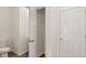 Hallway view featuring a closet, bathroom, and white trim with light colored walls and flooring at 290 Silver Moon Drive # 111, Loganville, GA 30052