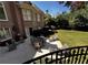 View of the backyard from the wrought iron fence, featuring a lush lawn and outdoor dining area at 9390 Colonnade Trl, Johns Creek, GA 30022