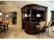 Luxurious basement bar with carved wood details, seating, and custom lighting at 9390 Colonnade Trl, Johns Creek, GA 30022