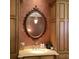 Close up of the sink and countertop in the elegant bathroom with decorative mirror and sconce lighting at 9390 Colonnade Trl, Johns Creek, GA 30022