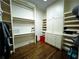 Walk-in closet provides ample storage with built-in shelves and drawers, and hardwood floors at 9390 Colonnade Trl, Johns Creek, GA 30022