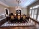 Formal dining room features a chandelier, dark wood floors, and large window at 9390 Colonnade Trl, Johns Creek, GA 30022