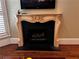 Close up of the fireplace with a decorative mantle, dark tile and hardwood floors at 9390 Colonnade Trl, Johns Creek, GA 30022