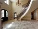 Elegant foyer boasts travertine tile, wrought iron staircase, and decorative trim, creating a grand entrance at 9390 Colonnade Trl, Johns Creek, GA 30022