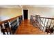 Hallway with beautiful hardwood floors and decorative iron railing at 9390 Colonnade Trl, Johns Creek, GA 30022