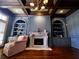 Elegant living room featuring custom built-ins, fireplace, beautiful hardwood floors, and coffered ceilings at 9390 Colonnade Trl, Johns Creek, GA 30022