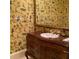 Unique powder room with custom vanity and eclectic wallpaper at 9390 Colonnade Trl, Johns Creek, GA 30022