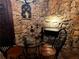 Wine cellar features a table, chairs, stone walls and an ornate fireplace at 9390 Colonnade Trl, Johns Creek, GA 30022