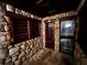 Stone walled wine cellar with custom shelving and a refrigerated wine storage system; ideal for wine collectors at 9390 Colonnade Trl, Johns Creek, GA 30022