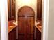 Private wine cellar featuring custom cabinetry and a wood door at 9390 Colonnade Trl, Johns Creek, GA 30022