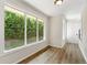 Bright hallway with wood-look flooring, white walls, and a view of a well manicured yard at 1371 Branch Dr, Tucker, GA 30084