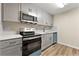 Updated kitchen features stainless steel appliances, gray cabinetry, and modern countertops and backsplash at 1371 Branch Dr, Tucker, GA 30084