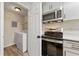 The kitchen features modern stainless steel appliances next to a laundry area at 1371 Branch Dr, Tucker, GA 30084