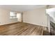 Living room with views into kitchen, wood-look floors, fireplace, and neutral paint at 1371 Branch Dr, Tucker, GA 30084