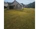 View of the spacious grassy backyard and rear exterior of the home, showing a neighbor's house to the left at 1750 Stone Meadow Rd, Lithonia, GA 30058
