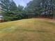 Secluded backyard featuring a lush green lawn and mature trees, offering privacy and tranquility at 1750 Stone Meadow Rd, Lithonia, GA 30058