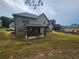 View of the spacious, grassy backyard and rear of the home, including a covered patio at 1750 Stone Meadow Rd, Lithonia, GA 30058