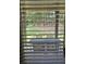 View of private backyard with a patio table and chairs, seen through window blinds at 1750 Stone Meadow Rd, Lithonia, GA 30058