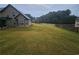 View of the spacious grassy backyard and rear exterior of the home, showing a neighbor's house to the left at 1750 Stone Meadow Rd, Lithonia, GA 30058