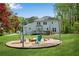 Exterior view of a two-story home showcasing a fire pit area, deck, and well-maintained lawn at 1953 Windcrest Sw Dr, Lilburn, GA 30047