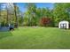 Large backyard features a fire pit, shed, deck, and plenty of grassy open space at 1953 Windcrest Sw Dr, Lilburn, GA 30047