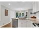 Updated kitchen with stainless dishwasher, granite counters, and white cabinets, flooded in natural light at 1953 Windcrest Sw Dr, Lilburn, GA 30047