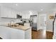 Bright kitchen features white cabinets, stainless steel appliances, granite countertops, and wood floors at 1953 Windcrest Sw Dr, Lilburn, GA 30047