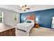 Spacious main bedroom features a blue accent wall, ceiling fan, and bedside tables with lamps at 1953 Windcrest Sw Dr, Lilburn, GA 30047