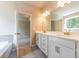 Modern bathroom with double vanity, quartz countertop, tiled flooring and a soaking tub at 4082 Adler Cir, Buford, GA 30519