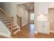 Bright foyer with wood stairs and adjacent storage, showcasing neutral tones and wood floors for a welcoming entrance at 4082 Adler Cir, Buford, GA 30519
