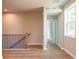 Well-lit hallway showcasing hardwood floors, iron railing, and a view of a bedroom with plush carpet at 4082 Adler Cir, Buford, GA 30519