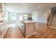 Kitchen features white cabinets, stainless steel appliances, a center island, and hardwood floors at 4082 Adler Cir, Buford, GA 30519