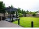 Well-maintained backyard with lush grass, wooden fence, swing set, and barbecue grill at 552 Warrenton Run Dr, Sugar Hill, GA 30518