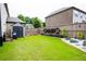 Spacious backyard with green lawn, storage shed, garden feature, and wooden fence at 552 Warrenton Run Dr, Sugar Hill, GA 30518